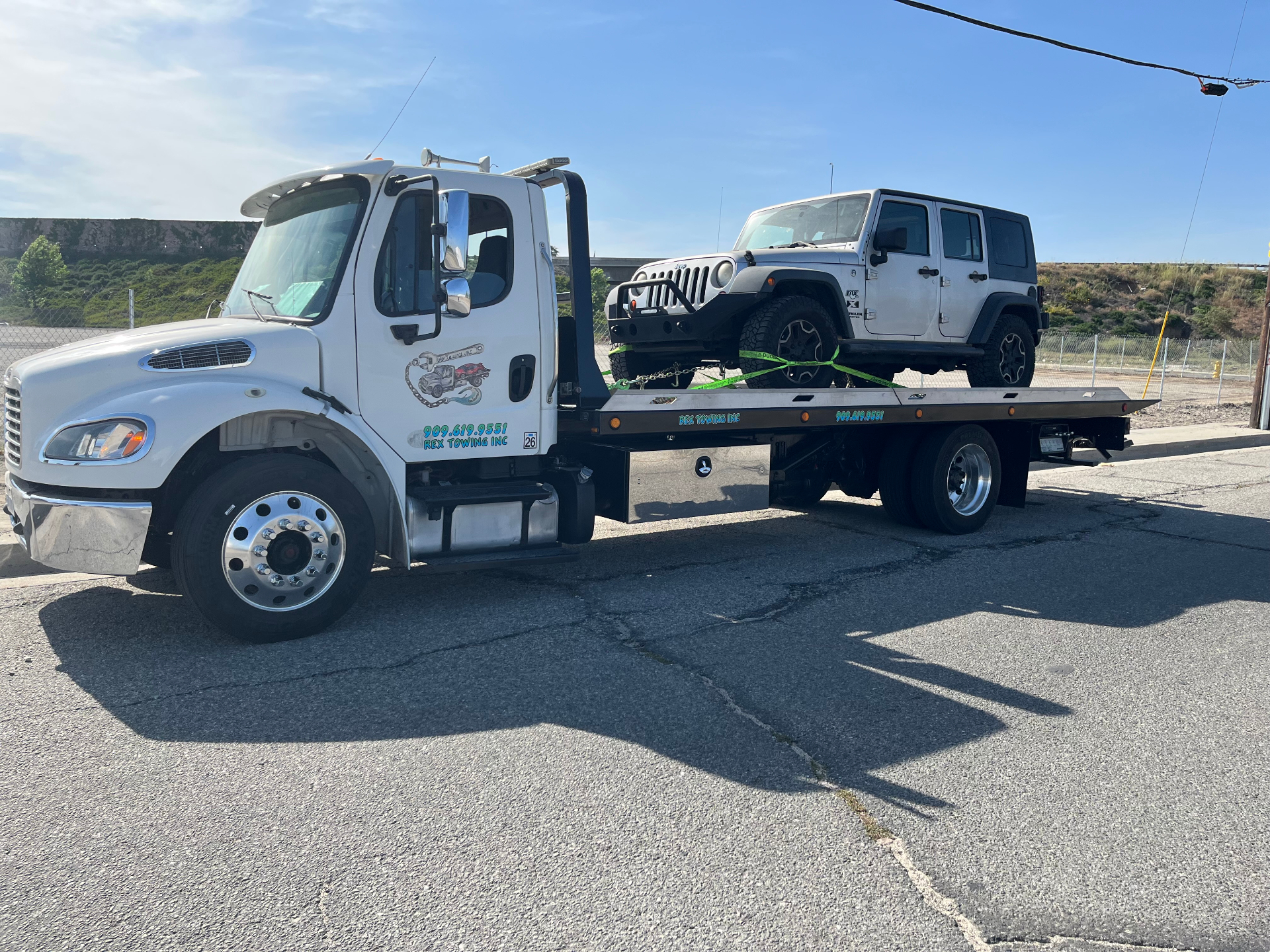Rex Towing Inc tow truck driver helping a customer roadside in San Bernardino, CA